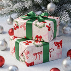 Two stacked gifts wrapped in Pink Bows & Wreaths paper with green ribbon, among silver and red ornaments