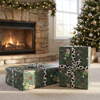 Two gifts wrapped in Western Christmas paper with cow-print ribbon, by a fireplace